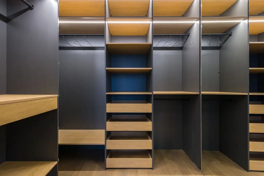 The inside of a fitted wardrobe: hanging space, drawers and open shelving